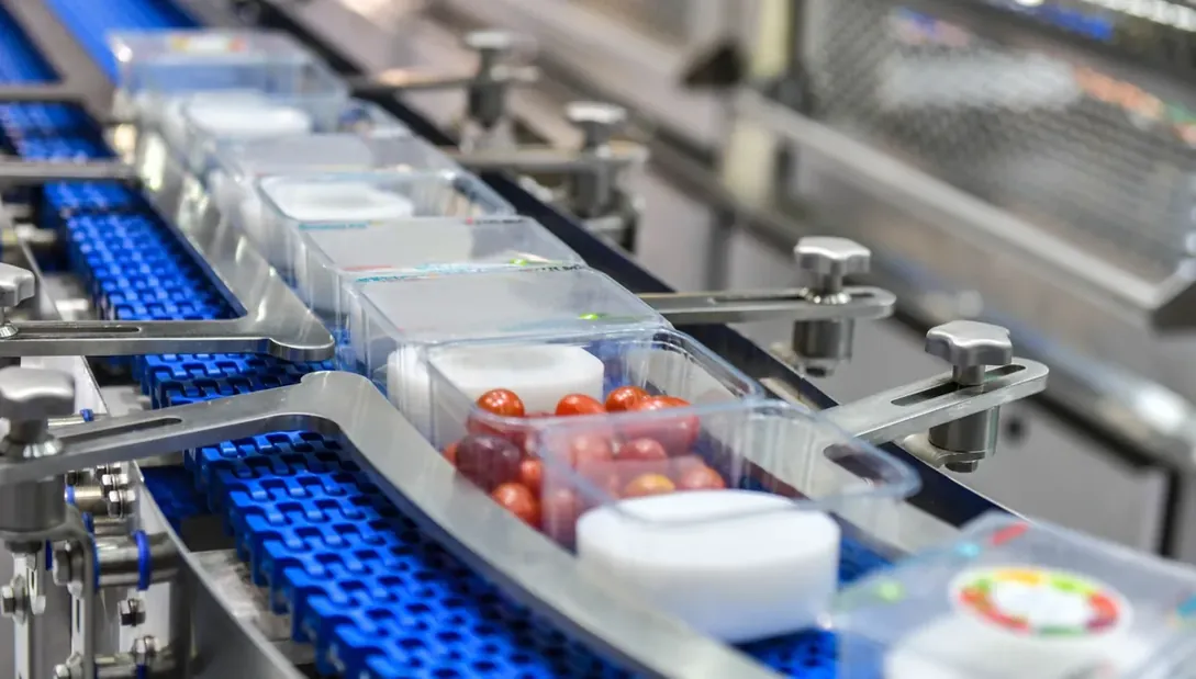 Frascos azuis percorrendo esteira de produção